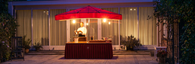 De poffertjeskraam van Pauls Poffertjes sfeervol verlicht in de avond