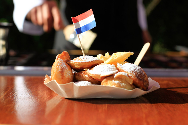 Poffertjes geserveerd op schaaltje met vorkje, klaar om te eten